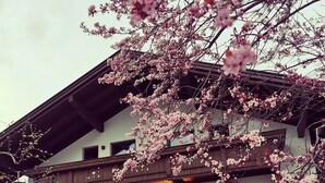 A two-story building with a balcony and a covered outdoor seating area. - New, stylish top floor apartement, free Wifi, bus stop directly at the house (Ramsau im Zillertal)