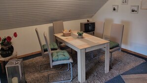 A dining area with a table, chairs, a microwave, and a small plant on the table. - Enjoy the tranquility of this landscape that has something to offer for everyone. Dollard (Bunde-Dollart)