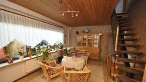 A cozy room with wicker furniture, a wooden staircase, and a brick wall. - Enjoy the tranquility of this landscape that has something to offer for everyone. Dollard (Bunde-Dollart)