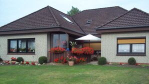 A two-story house with a brick facade, large windows, and a well-maintained lawn. - Enjoy the tranquility of this landscape that has something to offer for everyone. Dollard (Bunde-Dollart)