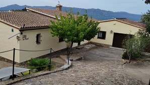 A building with a tiled roof, a chain-locked entrance, and a stone wall.