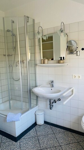 Een haardroger, handdoeken, zeep, toiletpapier