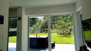 A room with a sliding glass door leading to a backyard with a patio and a lawn. - Apartment in a quiet location (Fügenberg)