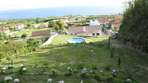 Un barrio residencial con piscina, casas y vista al mar.