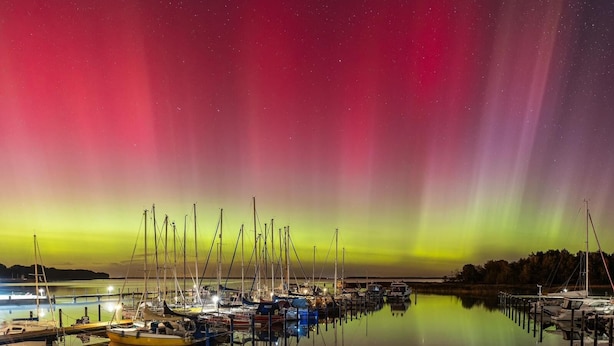 Een jachthaven met boten afgemeerd onder een levendig poollicht.