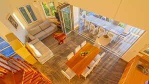 A spacious living area with a wooden dining table, white sofas, and a glass sliding door leading to an outdoor patio. - Beach Villa: private bathing area, sandy beach, WiFi, ideal for families (Novalja)