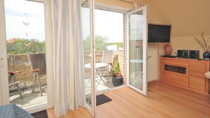 Een kamer met een schuifglazen deur die uitkomt op een terras.