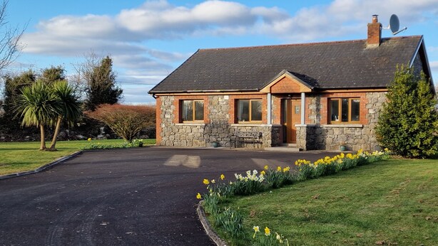 A stone house with a pitched roof, a front porch, and a driveway leading to the entrance. - Cottage on Lough Ree / River Shannon in the heart of Ireland (Newtowncashel)