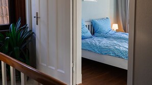 A room with a bed, a window, and a door.