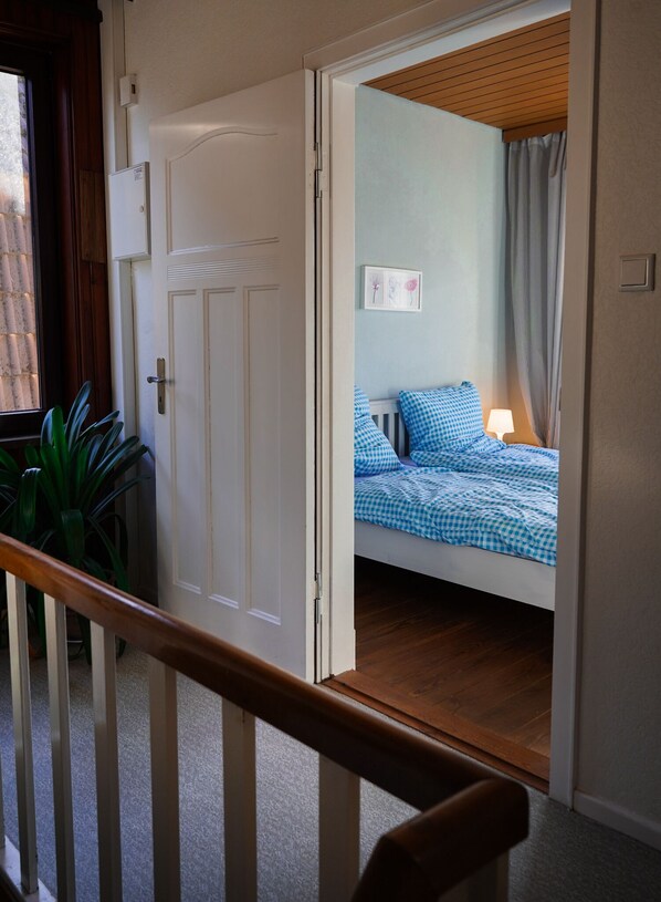 Une pièce avec un lit, une fenêtre et une porte.