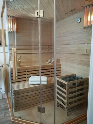 Et sauna-rum med træbænke og en glasvæg.