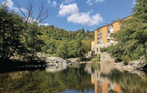 Ein Hotel mit einer Steinfassade, mehreren Balkonen und Blick auf einen Fluss.