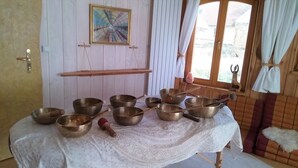 A room with a table covered by a lace tablecloth, holding several metal bowls and wooden spoons. - Holiday apartment in a tiny village - pets welcome (Nordwestuckermark)
