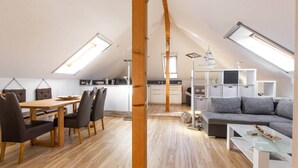 A spacious loft apartment with a dining area, kitchen, and living space.