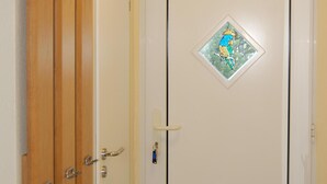 Eine weiße Tür mit einem kleinen Fenster und einem Aufkleber mit einer Zeichentrickfigur.