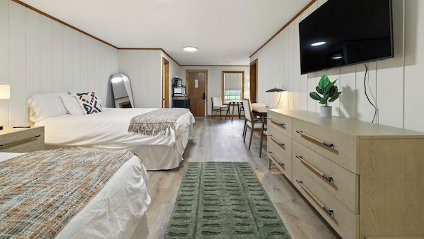 A hotel room with two beds, a TV, a desk, and a dresser. - Hillside (Luray)
