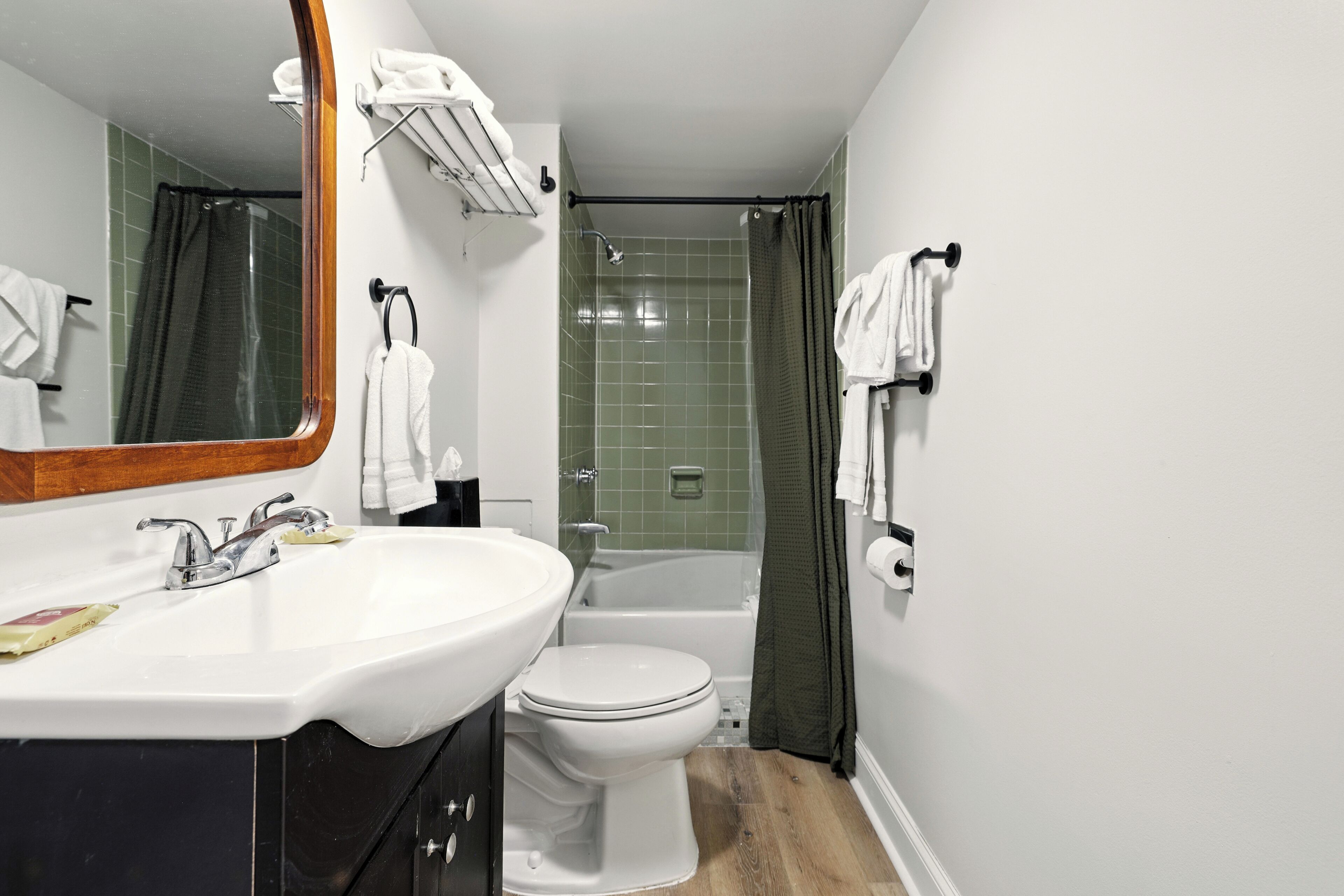 A bathroom with a sink, toilet, and shower area.