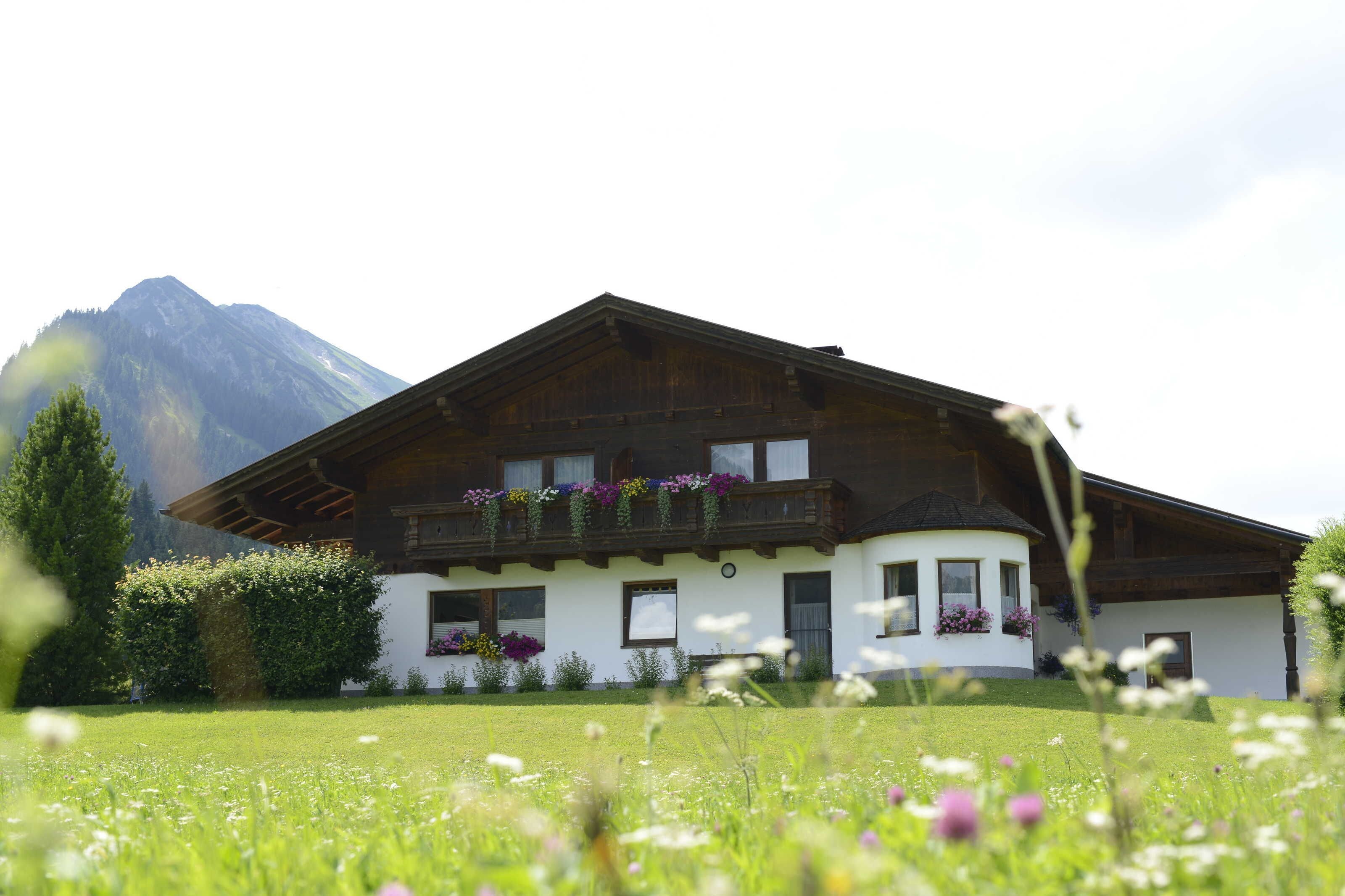 A chalet with a sloped roof, wooden balconies, and flower boxes.
