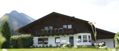A chalet with a sloped roof, wooden balconies, and flower boxes.