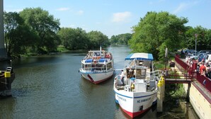 A river with boats docked at a pier.