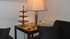 A lamp with a white shade on a wooden table next to a radiator. - A place in the sun in the Black Forest, for hiking, relaxing and enjoying (Ühlingen- Birkendorf)