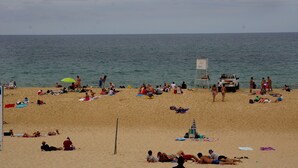 A beach with people sunbathing and walking. There is a lifeguard tower and a vehicle parked on the sand. - Restored holiday house with all comforts near the sea (Magescq)