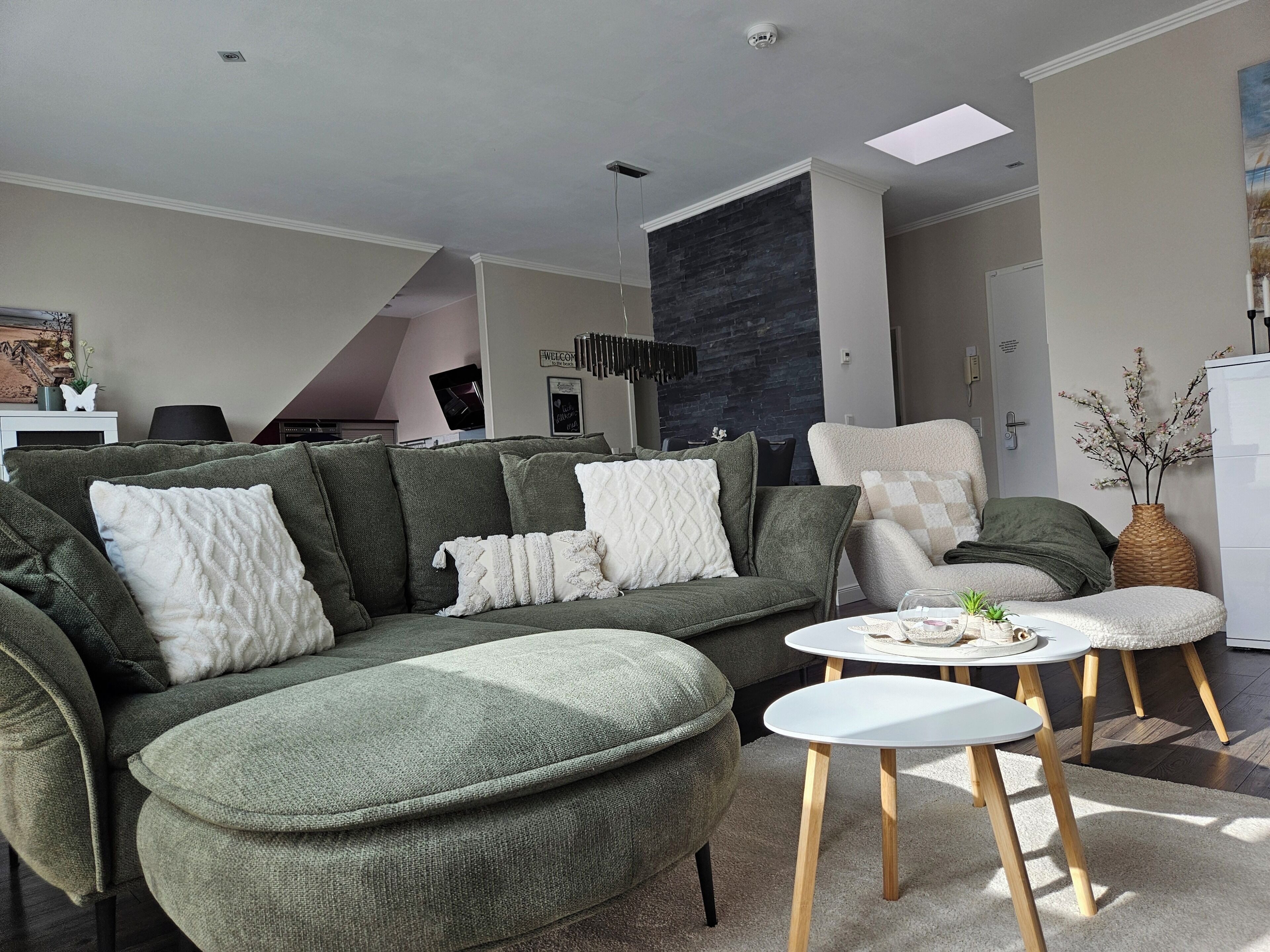 A modern living room with a sectional sofa, a round coffee table, and a dining area.