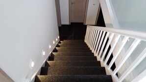 A staircase with a white railing and carpeted steps leading to a door. - Weissenhäuser Strand Ostsee Holiday house with high equipment (Wangels)
