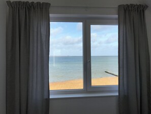 A window with a view of a beach and the sea. - Oceanhouse - First Row on the Water, Sauna, Balcony, 2 Floors, Guest WC (Olpenitz)