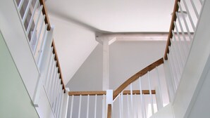 Una escalera de caracol con escalones de madera y barandillas blancas.