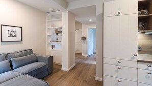 A modern living room with a grey sofa, white cabinets, and a wooden floor. - Apartment 5 - Edersee time out (Edertal)