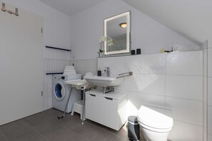Een douche, een haardroger, zeep, toiletpapier