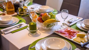 A breakfast setting with plates, cutlery, a fruit bowl, and a glass of juice. - Luxury wellness villa in a quiet area of Northern Istria (Lanišće)