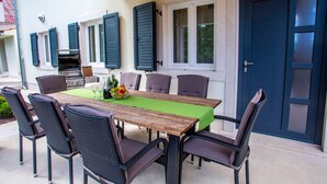 An outdoor dining area with a wooden table, six chairs, and a green tablecloth. - Luxury wellness villa in a quiet area of Northern Istria (Lanišće)
