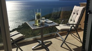 A balcony with a table set for two, overlooking a scenic view of the sea and distant mountains. - Private hillside location ★★★★ with special views, ideal for couples (Medveja)
