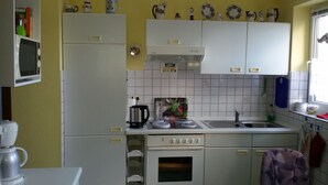 A compact kitchen with white cabinets, a microwave, a kettle, and a coffee maker. - Peaceful well furnished apartment near the North Sea spa Büsum (Westerdeichstrich)