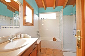 Een bad/douchecombinatie, een haardroger, een bidet, handdoeken