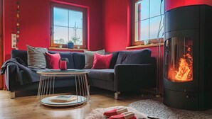 Una sala acogedora con un sofá, una mesa redonda de centro, una chimenea y una alfombra.
