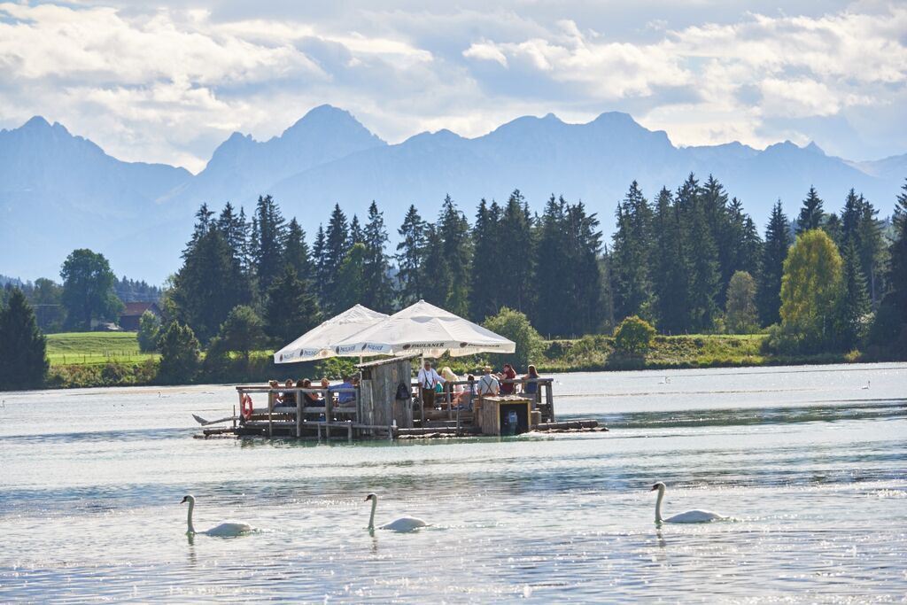 A floating structure with a covered seating area and a dock.