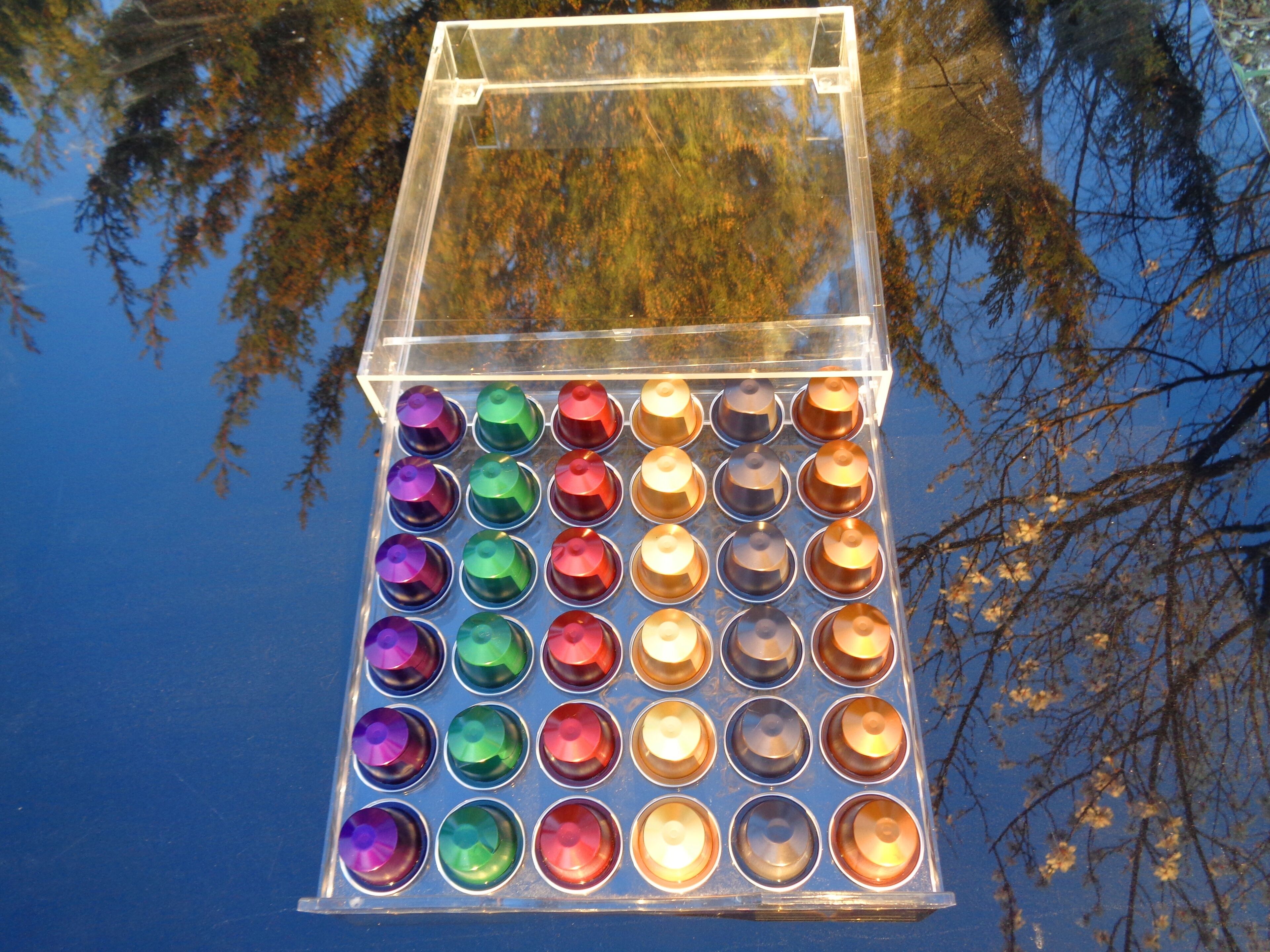 A transparent container with multiple compartments, each holding a cylindrical object.