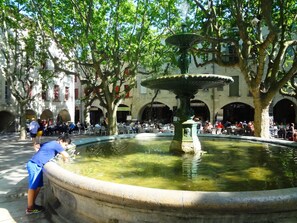 A courtyard with a fountain, trees, and outdoor seating areas.