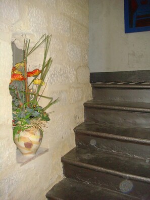 A staircase with a potted plant on the left.