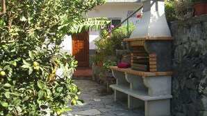 A stone pathway leading to a building with a wooden door and a stone oven. - Small house in a village, with a front yard, set back from the main street, with Wi-Fi (Valle Gran Rey)