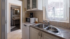 A modern kitchen with a built-in dishwasher, a double sink, a microwave, and a coffee maker. - Family-friendly, quiet location, near the beach, barbecue in the garden, (Poreč)