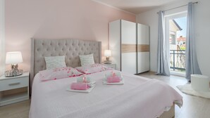 A bedroom with a large bed, a nightstand, a wardrobe, and a balcony with curtains. - Family-friendly, quiet location, near the beach, barbecue in the garden, (Poreč)