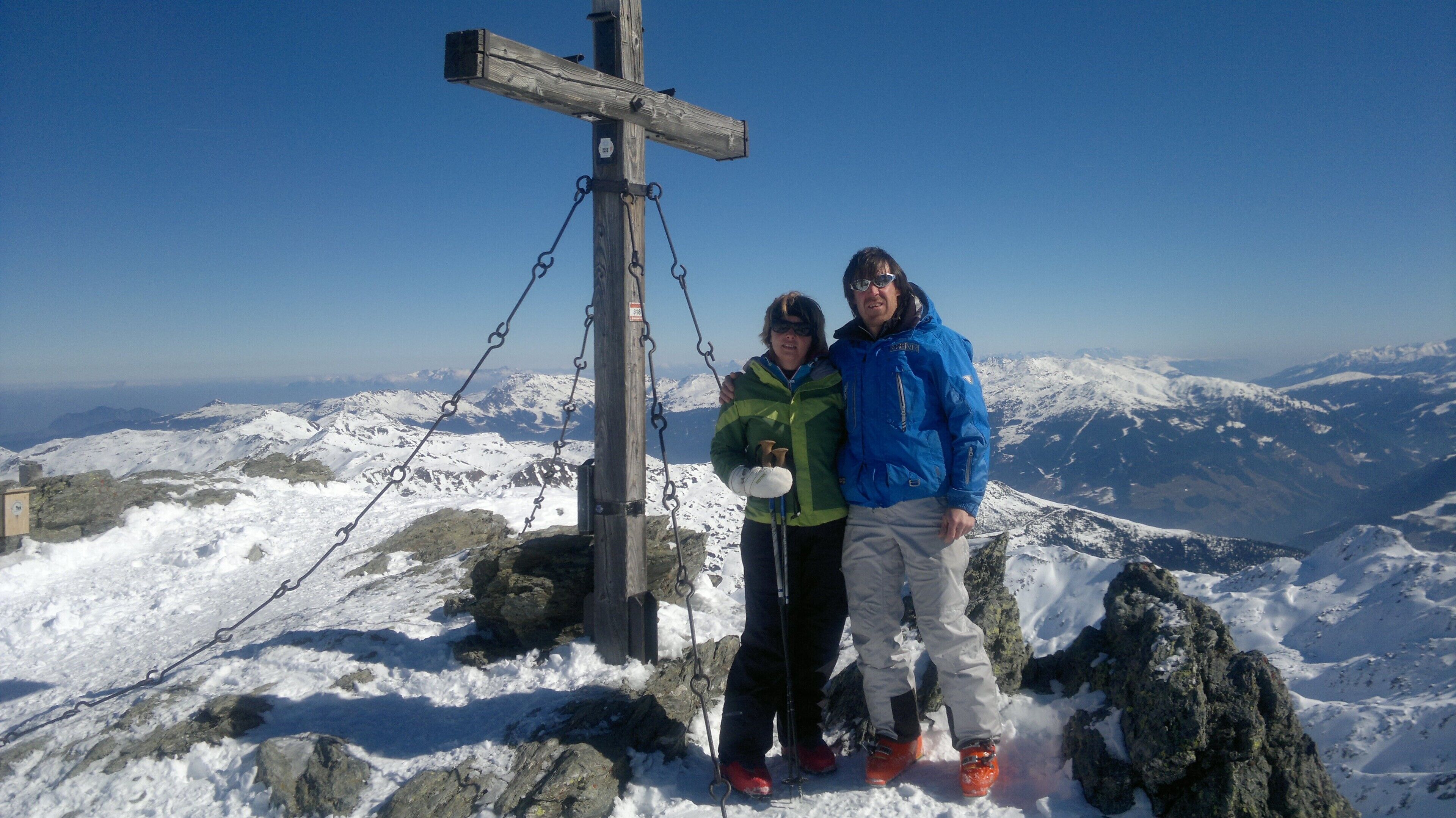 A snowy mountain landscape with a wooden cross and chains.