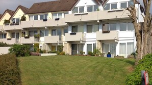 A row of modern apartment buildings with balconies, a well-maintained lawn, and mature trees. - Modern, premium lake view vacation apartment over 2 floors (Waldeck -Scheid)