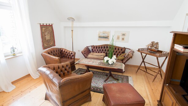 A living room with leather sofas, a coffee table, and a wooden cabinet. - Apartment Hörster in the center of Detmold (Detmold)
