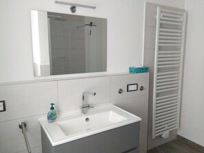 A bathroom with a white sink, a mirror, and a towel rack. - Rest and relaxation in a charming nature in every season! (Altenberg)