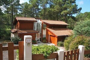 A wooden cabin with a tiled roof, surrounded by greenery. - Beautiful house with idyllic views G0268 (Lacanau)
